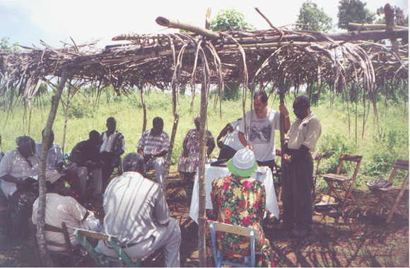 Bro. Kelly teaching the bible at a preaching point in
      Montagnac, Haiti, W.I.